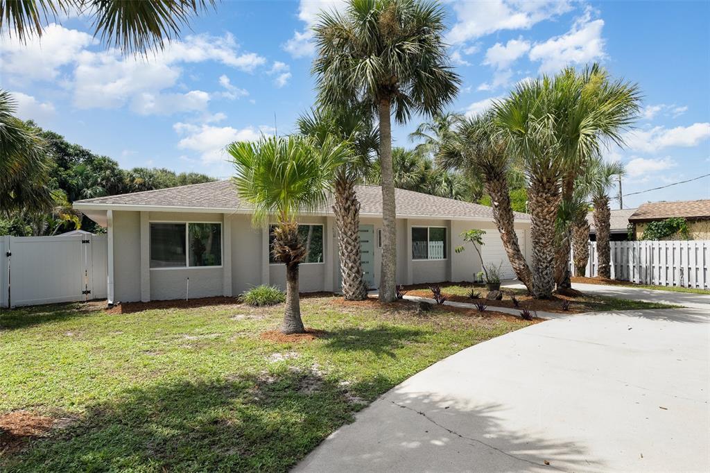A single-story house with a light-colored exterior, palm trees, and a concrete driveway — 125 MATANZAS ROAD, MELBOURNE BEACH, FL