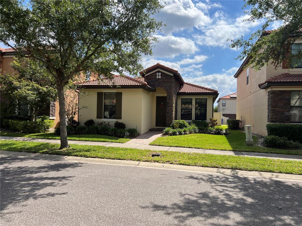 A single-story house with a stone-accented entryway, tile roof, and a manicured front lawn — 2002 FISHTAIL FERN WAY, OCOEE, FL