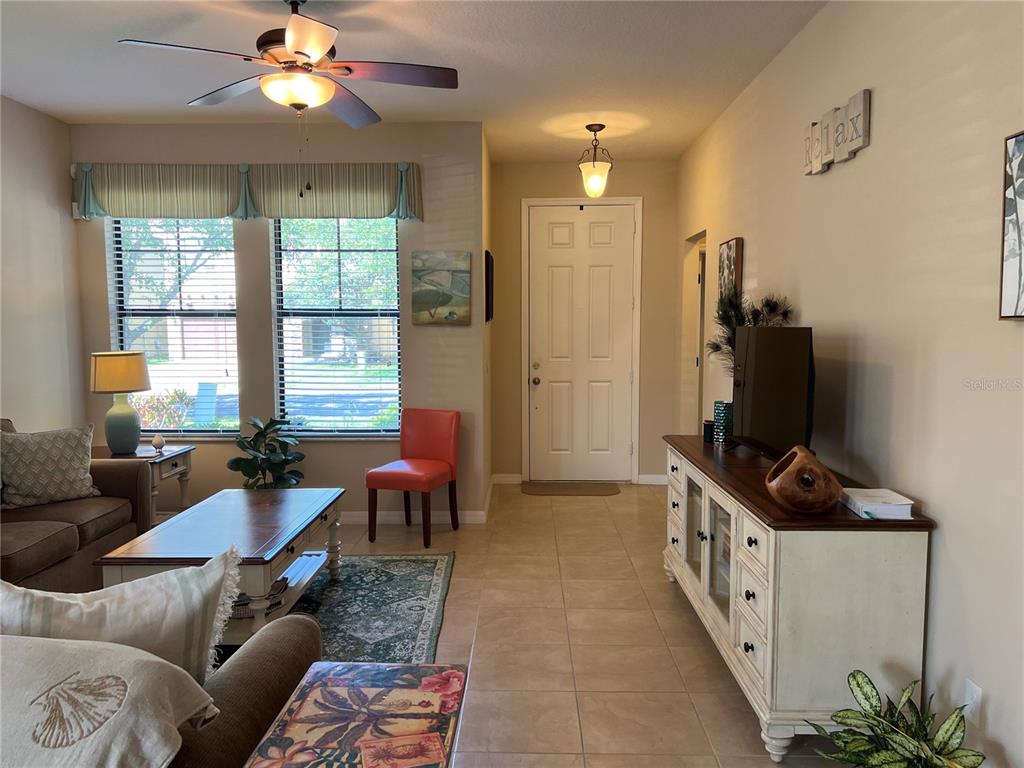 A kitchen with wood cabinets and a breakfast bar opens to a tiled dining area — 2002 FISHTAIL FERN WAY, OCOEE, FL