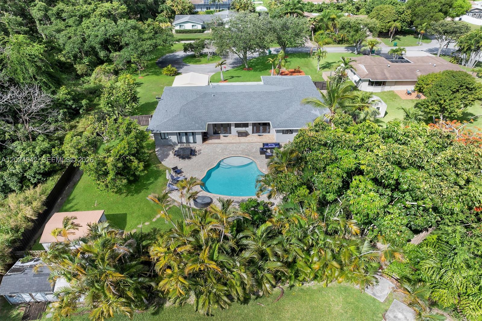 An aerial view shows a house with a gray roof, a pool, and lush landscaping — 8825 SW 185th Ter, Cutler Bay FL 33157, CUTLER BAY, FL