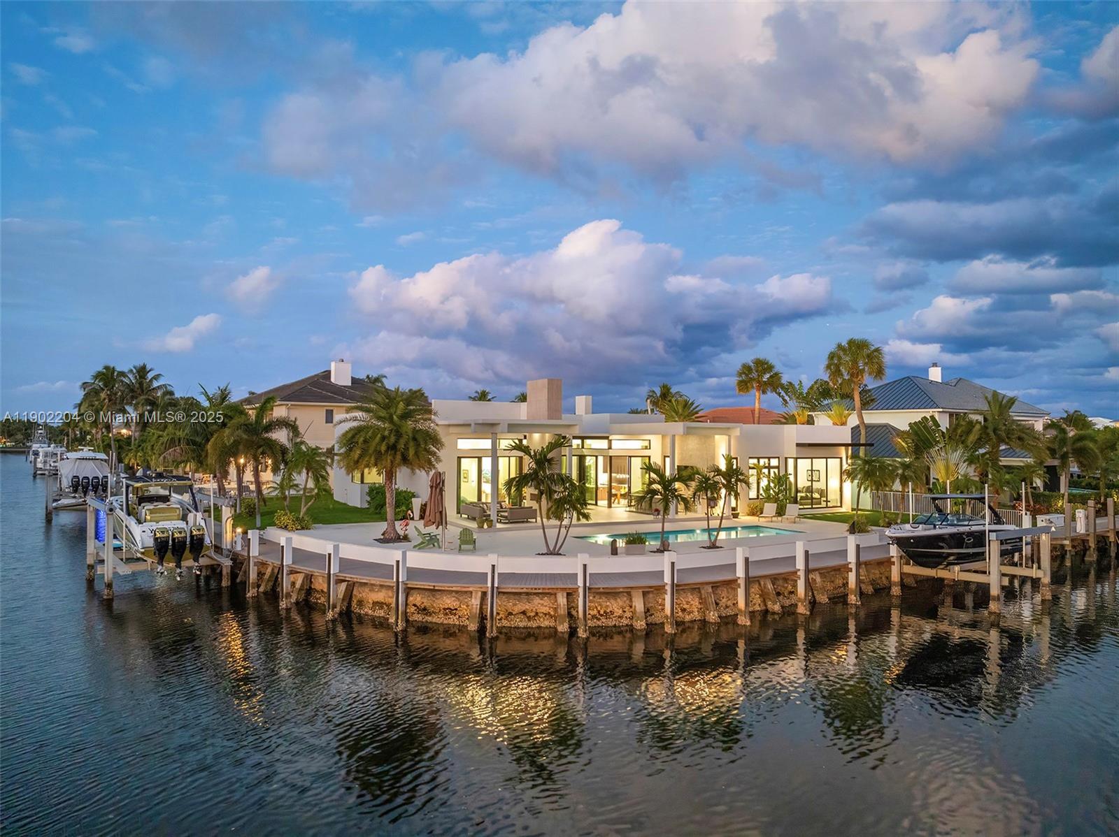 An aerial view of a modern waterfront house with a pool, dock, and two boats — 3701 NE 26th Ave # 1, Lighthouse Point FL 33064, LIGHTHOUSE POINT, FL