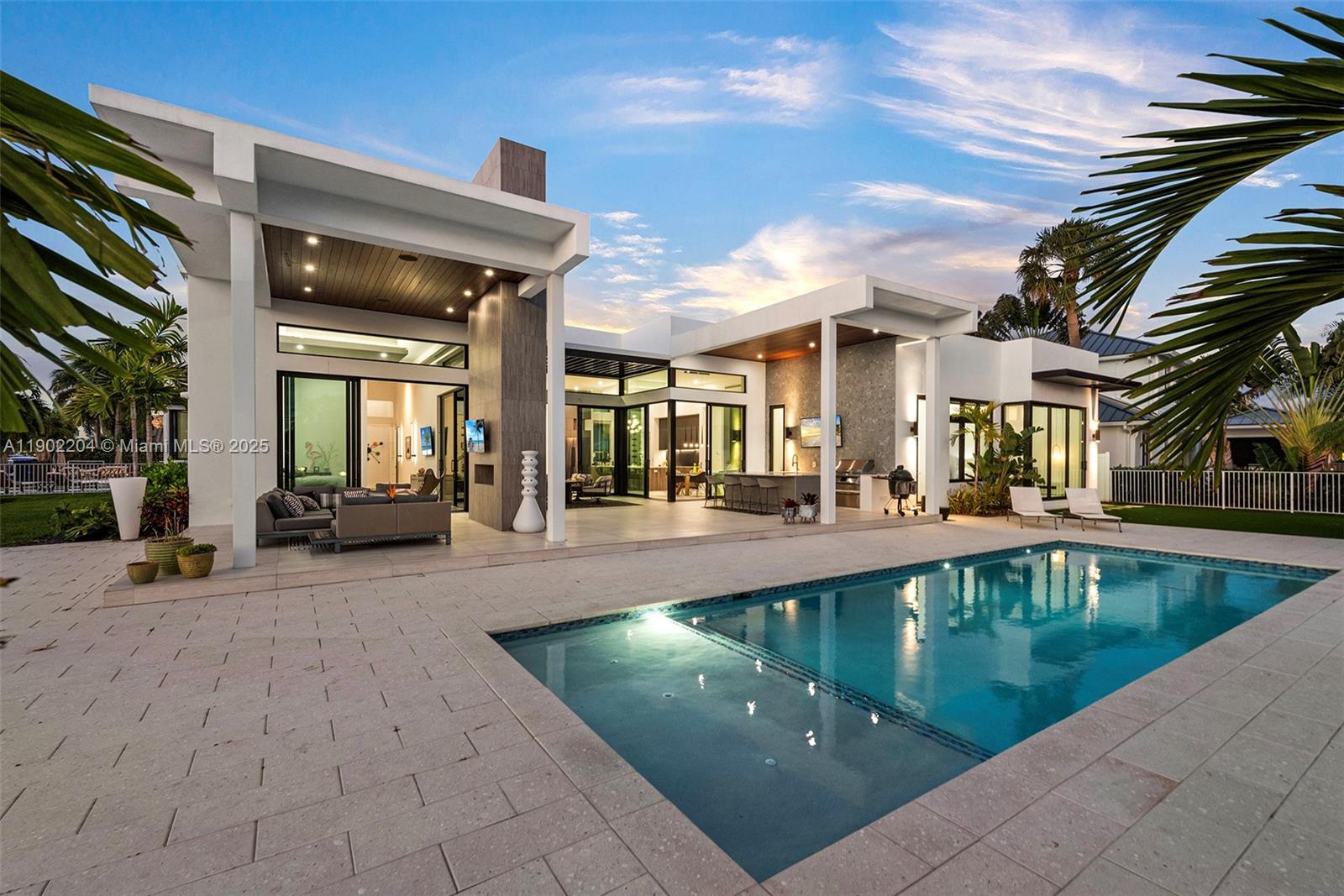 A modern house exterior features a swimming pool, covered patio, and outdoor kitchen area — 3701 NE 26th Ave # 1, Lighthouse Point FL 33064, LIGHTHOUSE POINT, FL