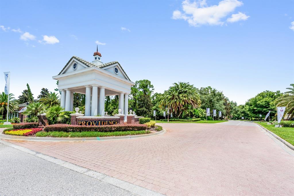 A white neoclassical monument with columns stands at the entrance of a residential community — 3135 CAMDEN WAY, DAVENPORT, FL
