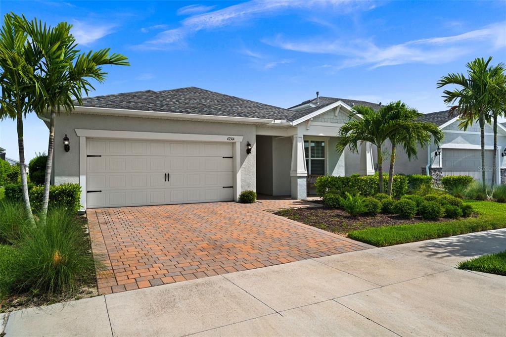 A single-story suburban house with a paved driveway, two-car garage, and palm trees — 42364 EDGEWATER DRIVE, PUNTA GORDA, FL
