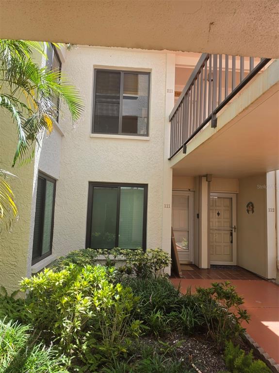 Exterior view of a two-story apartment building with a ground-level entrance and balcony — 6295 BAHIA DEL MAR CIRCLE UNIT 111, ST PETERSBURG, FL