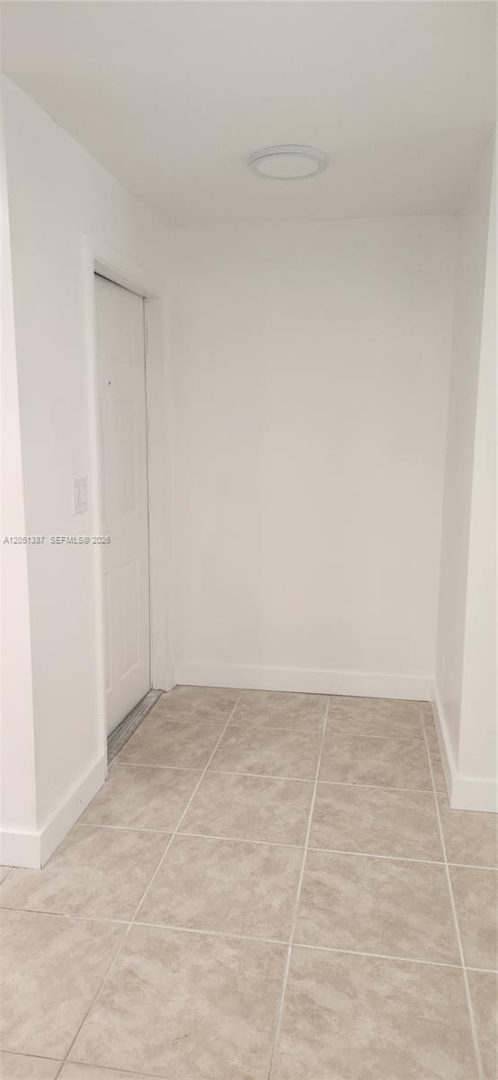 A small entryway features white walls, a white door, and light-colored tile flooring — 1599 Veracruz Ln, Weston FL 33327, WESTON, FL