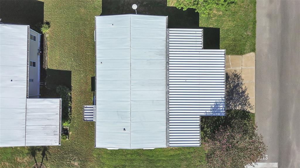 An aerial view shows the metal roofs of a mobile home and its adjacent carport — 4950 FOXWOOD BLVD, LAKELAND, FL