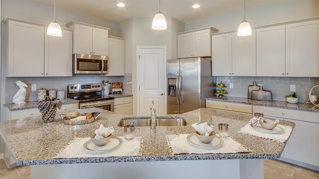 A kitchen features granite countertops, stainless steel appliances, light gray cabinets, and a central island — 4754 NW 39TH STREET ROAD, OCALA, FL