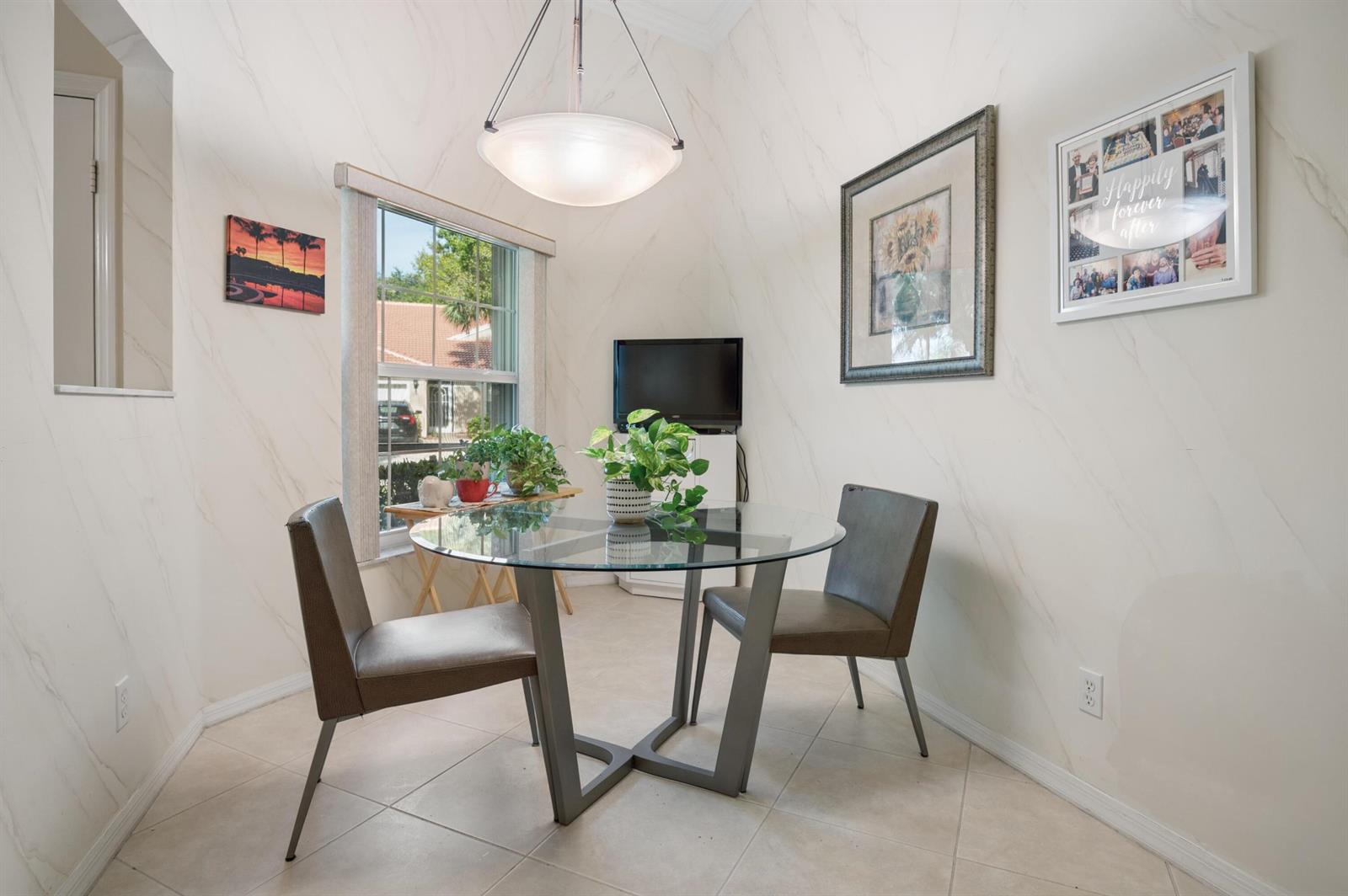 A dining nook features a glass-topped table, two chairs, and marble-patterned walls — 5053 TOSCANA Trail, Boynton Beach FL 33437, BOYNTON BEACH, FL