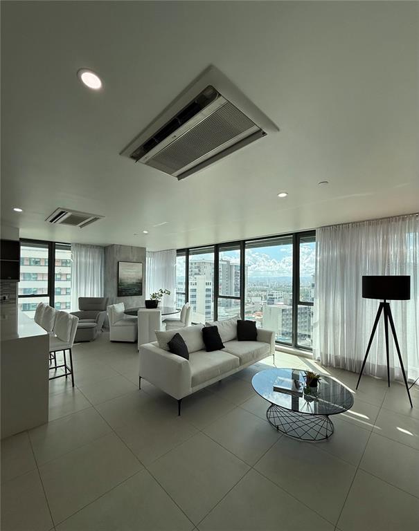 A modern living room features a white sofa, glass coffee table, and floor-to-ceiling windows — 1511 AVE. PONCE DE LEÓN TORRE DEL NORTE 1000 CIUDADELA UNIT 10144, SAN JUAN, PR