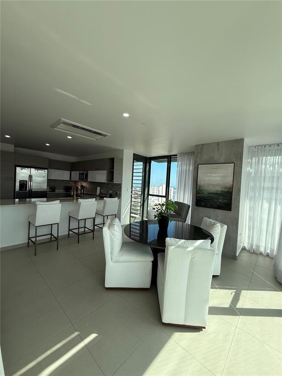 A modern kitchen and dining area featuring white chairs, a glass table, and city views — 1511 AVE. PONCE DE LEÓN TORRE DEL NORTE 1000 CIUDADELA UNIT 10144, SAN JUAN, PR
