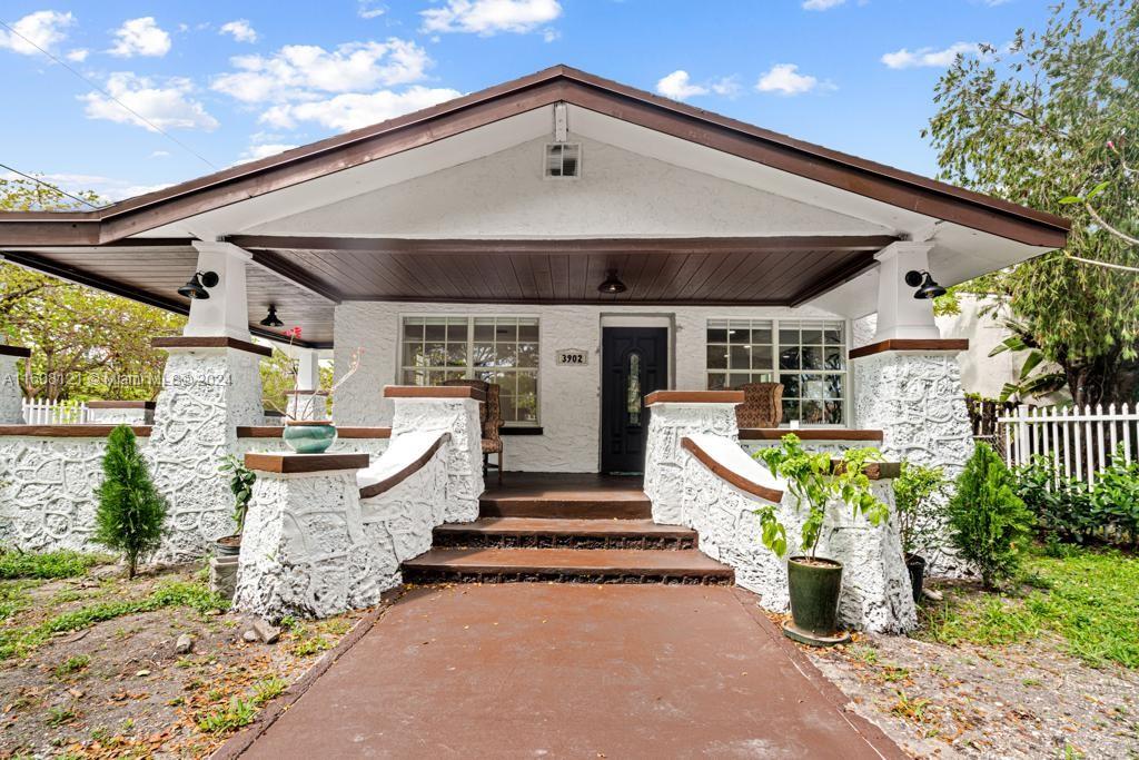 A white house with a covered front porch, stone pillars, and a brown walkway — 3902 NW 3rd Ave, Miami FL 33127, MIAMI, FL