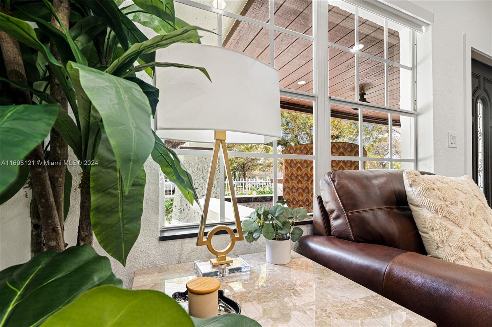 A living room features a marble-topped table, a modern gold lamp, and a leather sofa — 3902 NW 3rd Ave, Miami FL 33127, MIAMI, FL