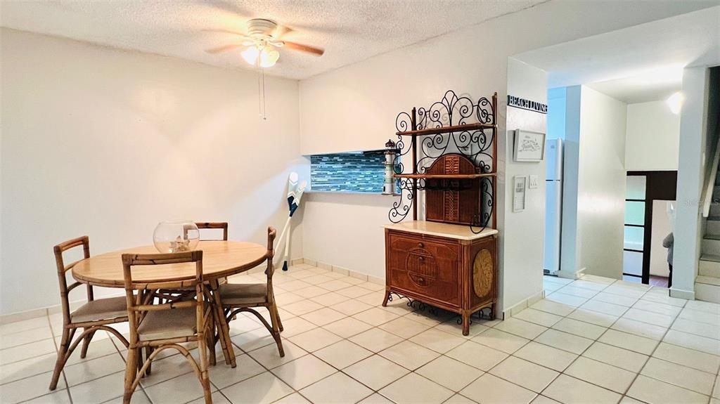 A dining area features a round bamboo table, matching chairs, and a decorative wrought-iron hutch — 1015 HARBOURSIDE DR. UNIT 1015, HUMACAO, PR