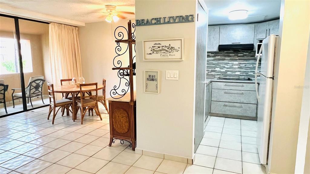 This interior view shows a dining area with tiled floors adjacent to a modern kitchen — 1015 HARBOURSIDE DR. UNIT 1015, HUMACAO, PR