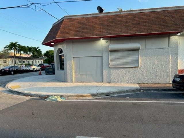 A corner commercial building with a brown shingled roof and a closed metal security shutter — 1400 SW 6th St, Miami FL 33135, MIAMI, FL