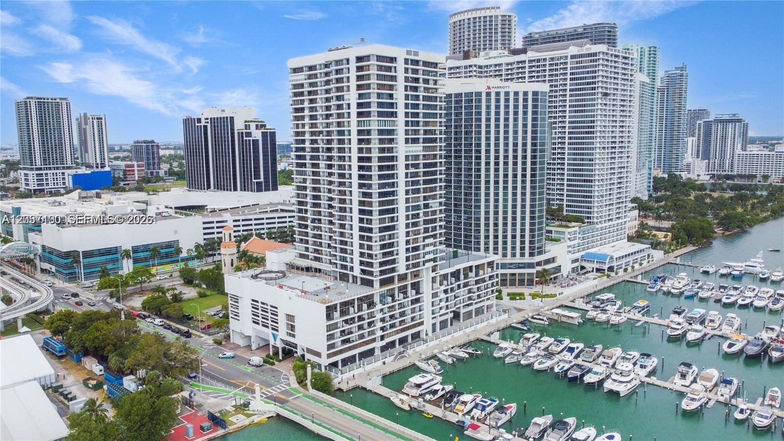 An aerial view shows a tall residential building complex situated next to a boat marina — 555 NE 15th St # 17E, Miami FL 33132, MIAMI, FL