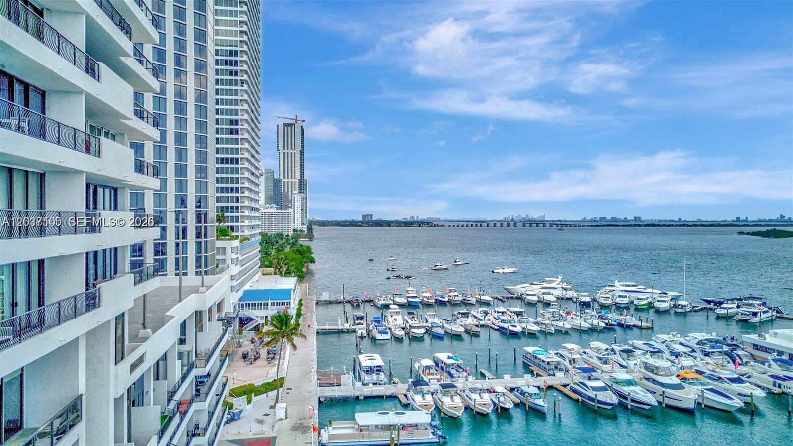 An elevated view shows a high-rise building overlooking a marina filled with numerous boats — 555 NE 15th St # 17E, Miami FL 33132, MIAMI, FL