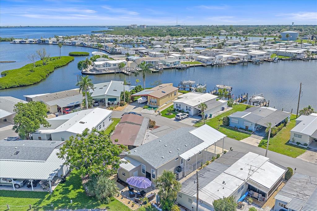 An aerial view shows a waterfront mobile home community with docks and surrounding vegetation — 203 BIMINI DRIVE, PALMETTO, FL