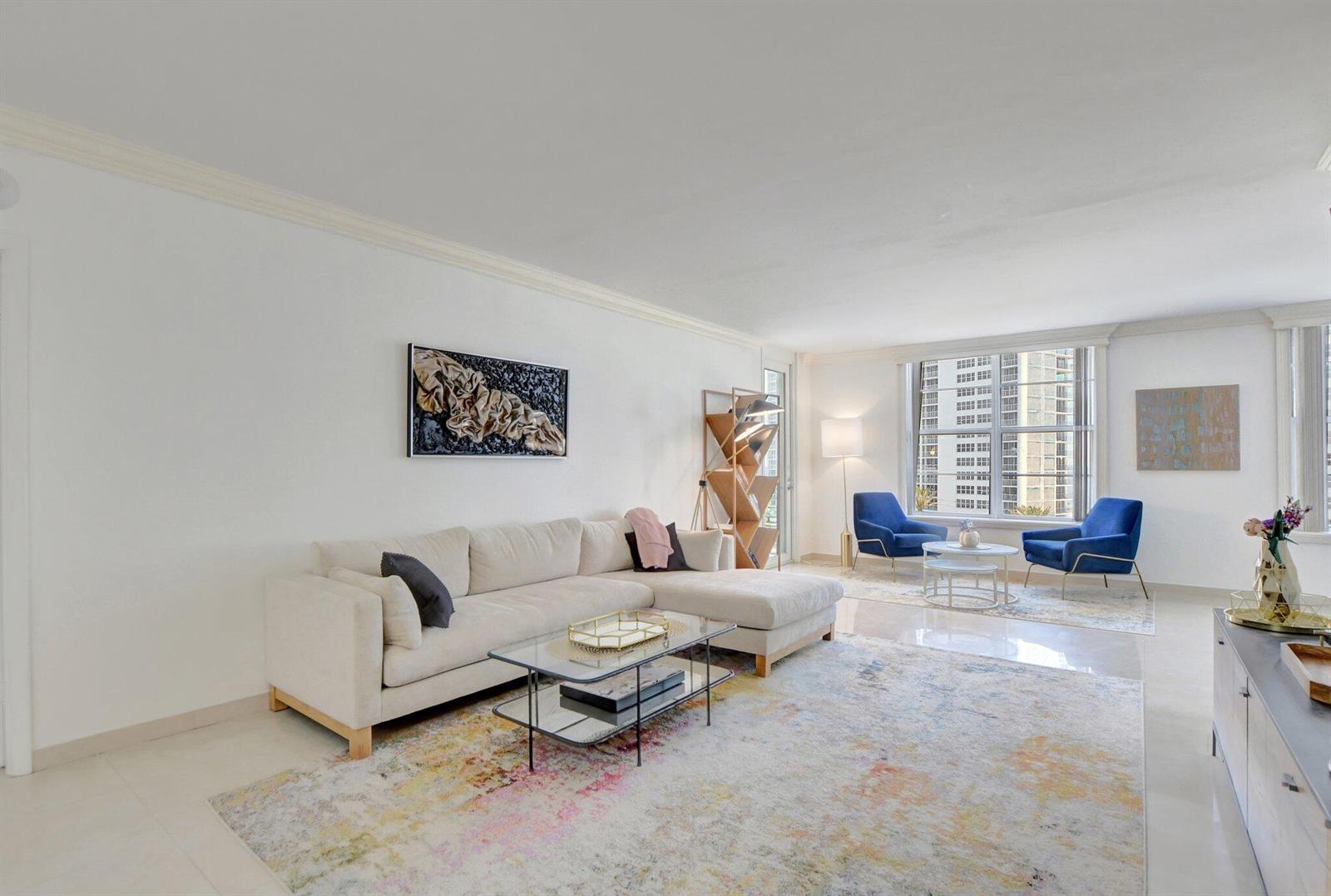 A bright living room features a beige sectional sofa, glass coffee table, and blue armchairs — 2851 S Ocean Boulevard # 6n, Boca Raton FL 33432, BOCA RATON, FL