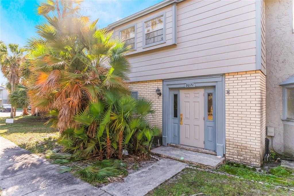 A two-story townhouse exterior features a light-colored brick facade, tan siding, and a palm tree — 3071 GEORGE MASON AVENUE UNIT 5, WINTER PARK, FL