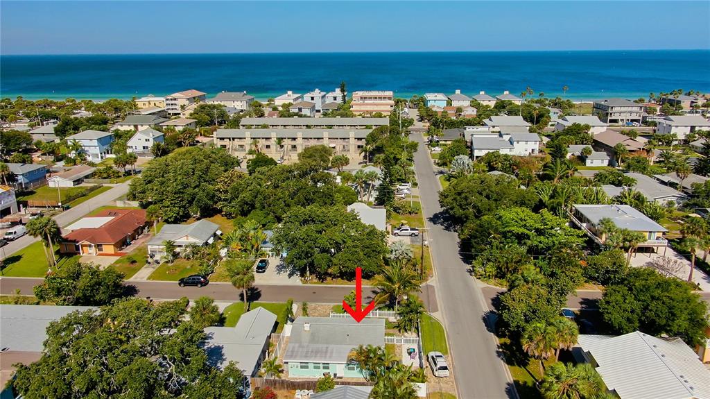 An aerial view shows a single-story house with a light-colored roof near a coastal road — 1907 2ND STREET, INDIAN ROCKS BEACH, FL