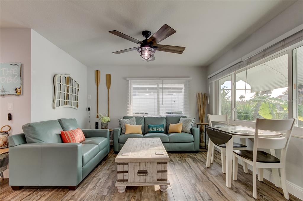 A living room features light blue sofas, a wooden coffee table, and a dining set — 1907 2ND STREET, INDIAN ROCKS BEACH, FL
