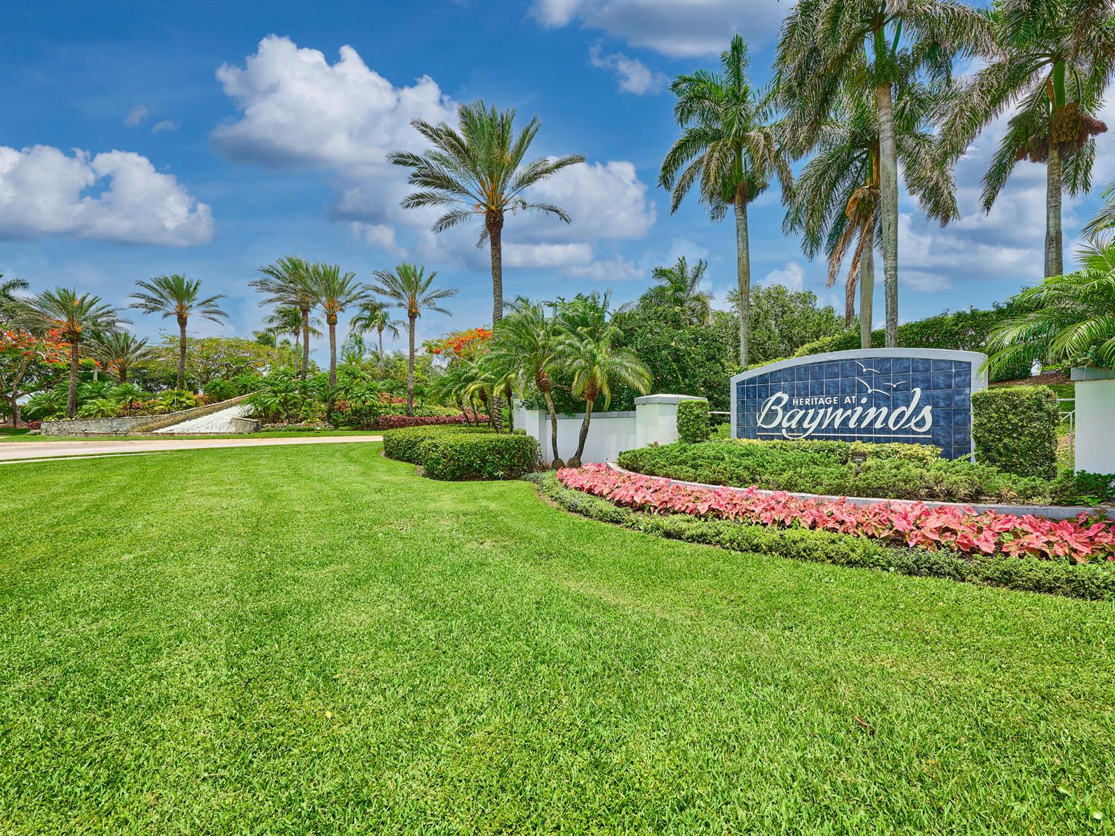 A stone-lined water feature cascades down a tiered slope surrounded by lush tropical landscaping — 2649 Clipper Circle, West Palm Beach FL 33411, WEST PALM BEACH, FL