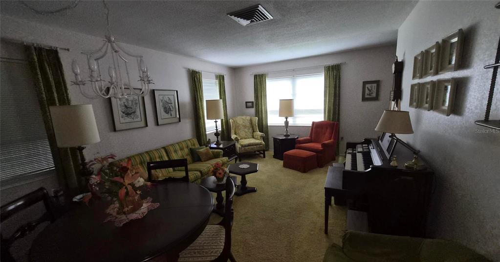 A living room features a piano, a sofa, armchairs, and a dining table — 2204 ORANGE BLOSSOM LANE, BRADENTON, FL