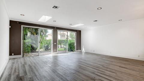 A spacious room with light wood-look flooring, recessed lighting, and large sliding glass doors — 6784 Via Regina, Boca Raton FL 33433, BOCA RATON, FL