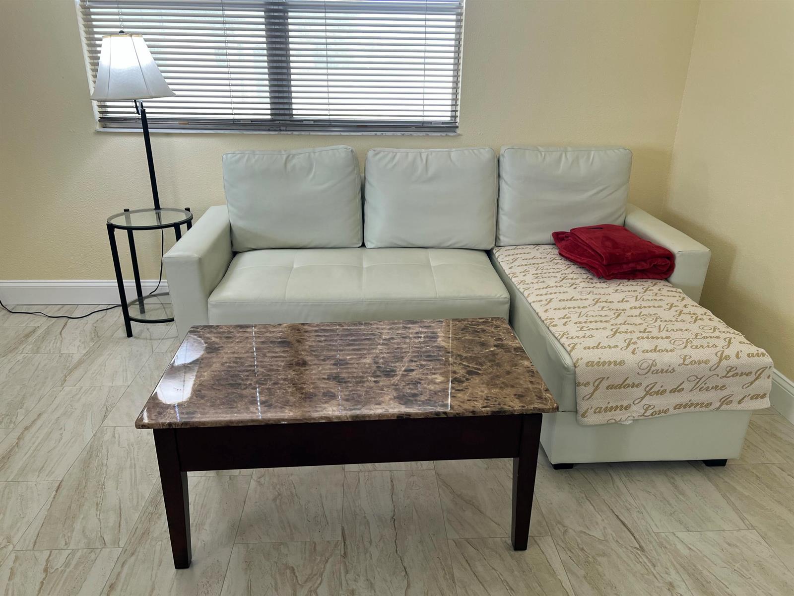 A living room features a white sectional sofa, a marble-topped coffee table, and a floor lamp — 711 Monaco Court, Delray Beach FL 33446, DELRAY BEACH, FL