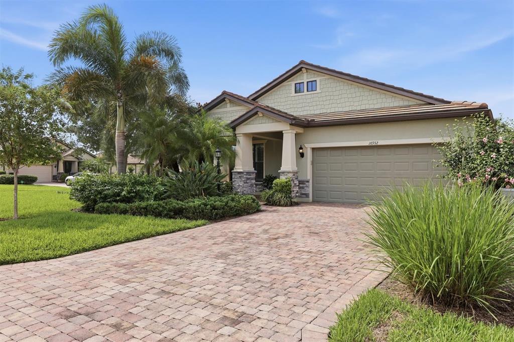 A single-story house with a paved driveway, stone-accented columns, and a two-car garage — 16932 PELHAM PLACE, LAKEWOOD RANCH, FL