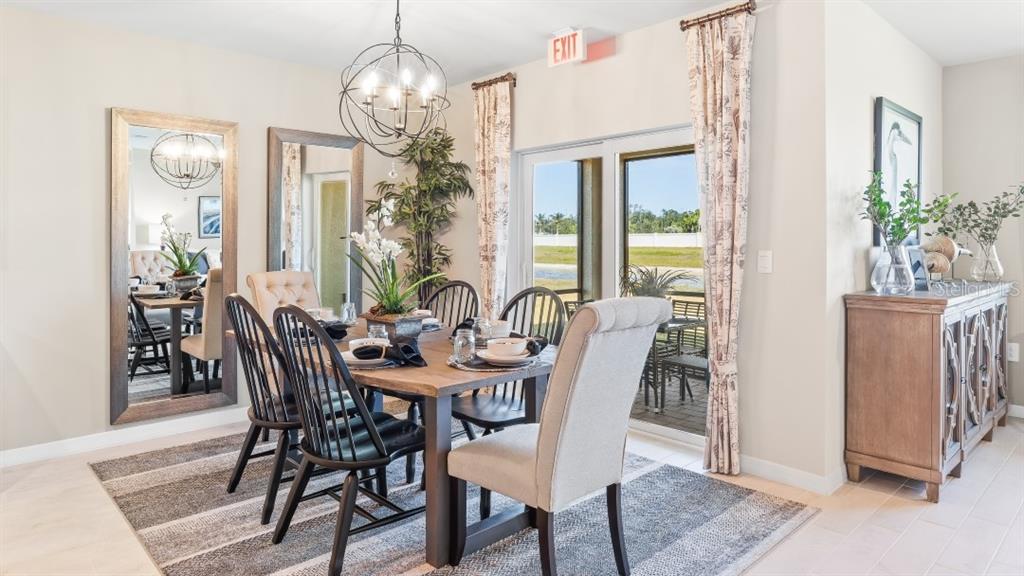 A dining room features a wooden table, black chairs, upholstered chairs, and a large mirror — 4912 TUSCOLA BOULEVARD, NORTH PORT, FL