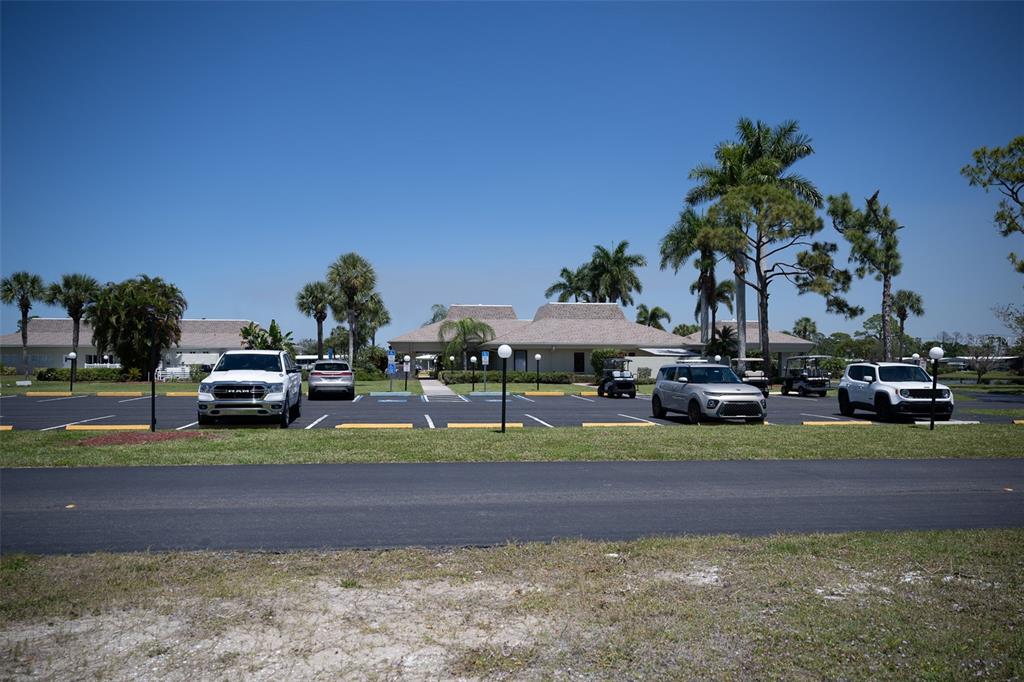 A parking lot sits in front of a low-rise building surrounded by palm trees — 307 ROBALO, NORTH PORT, FL