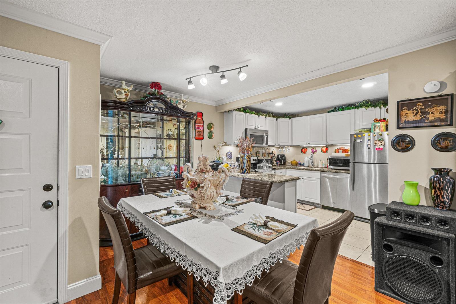 A dining area with a table and hutch opens into a kitchen with white cabinets — 526 Shady Pine Way # D2, FL 33415, FL