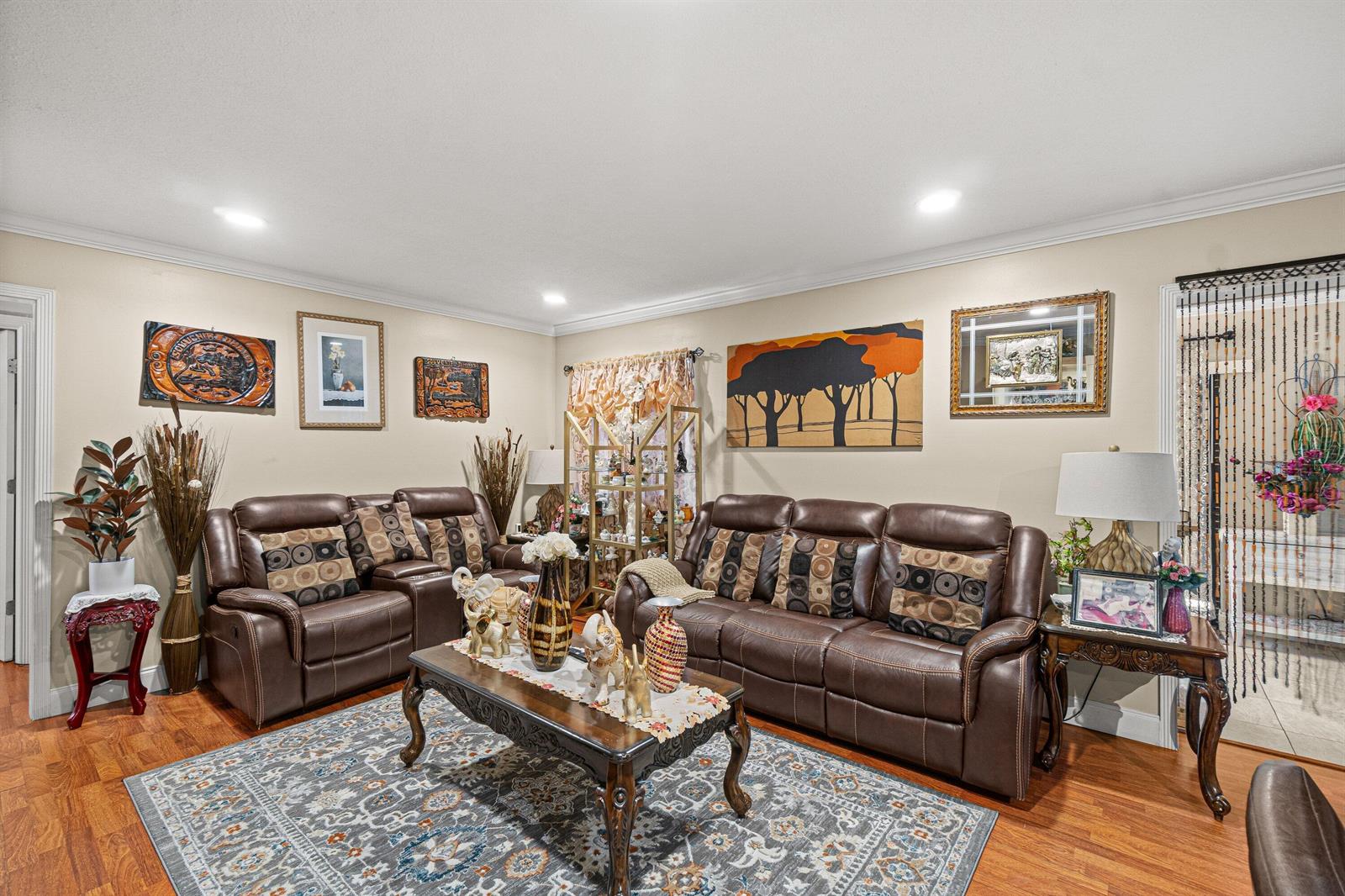 A living room features brown leather sofas, a patterned area rug, and various wall art — 526 Shady Pine Way # D2, FL 33415, FL