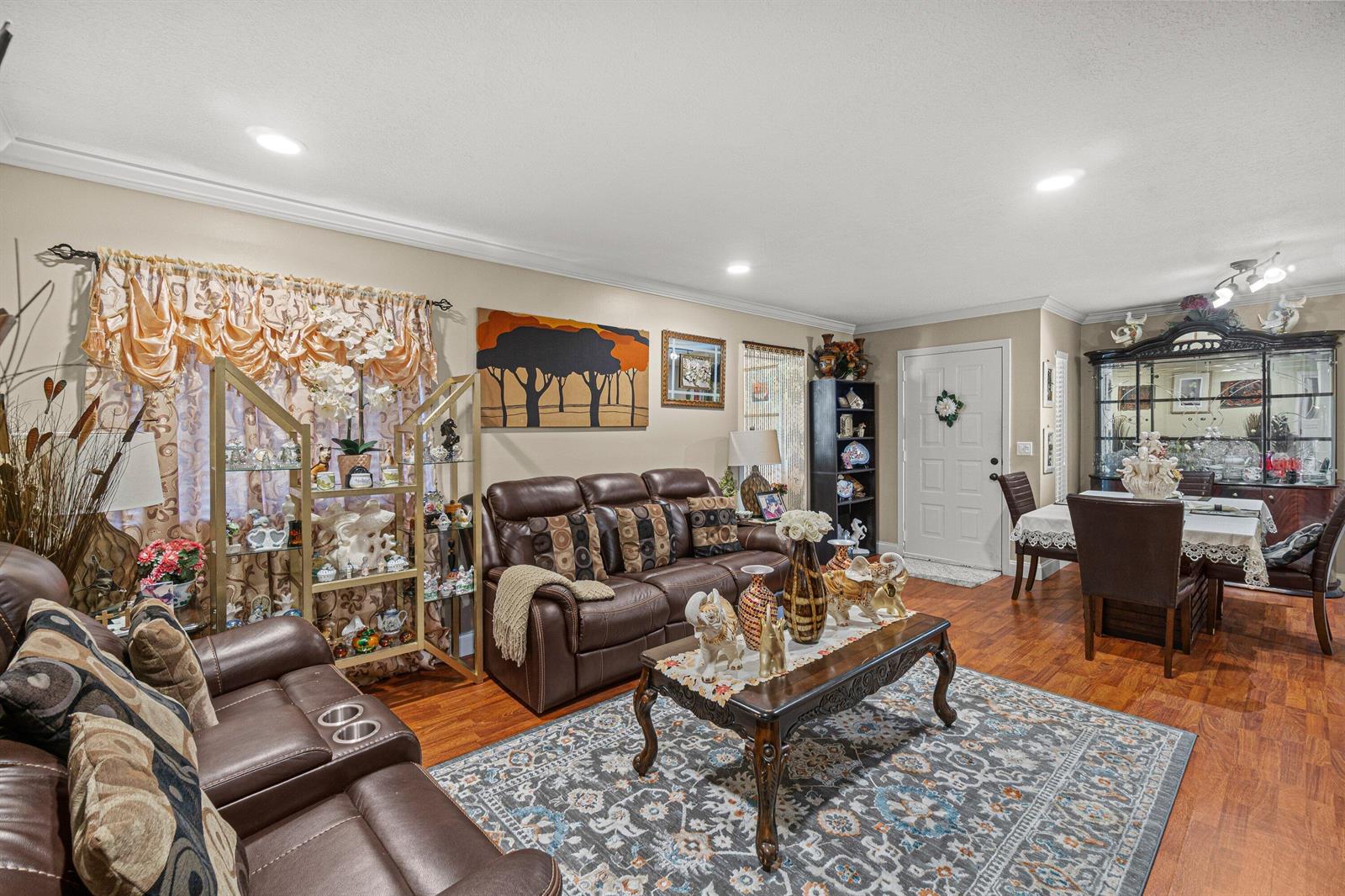 A living room with brown leather sofas, a patterned area rug, and a dining area — 526 Shady Pine Way # D2, FL 33415, FL