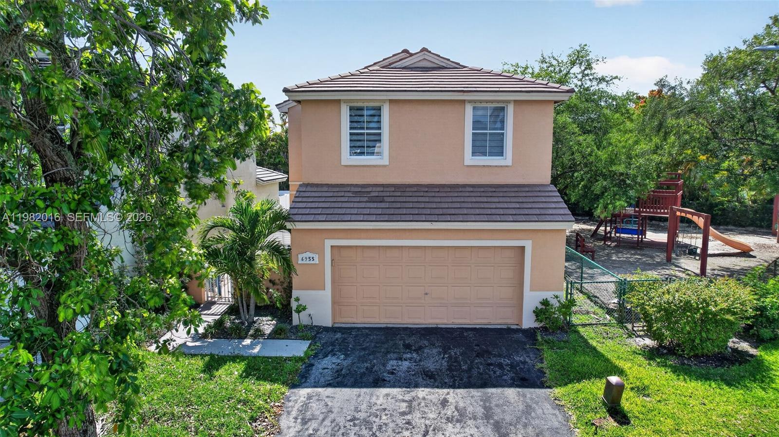 A two-story house with a tan stucco exterior, a brown tile roof, and a garage — 6955 SW 148th Ln, Davie FL 33331, DAVIE, FL