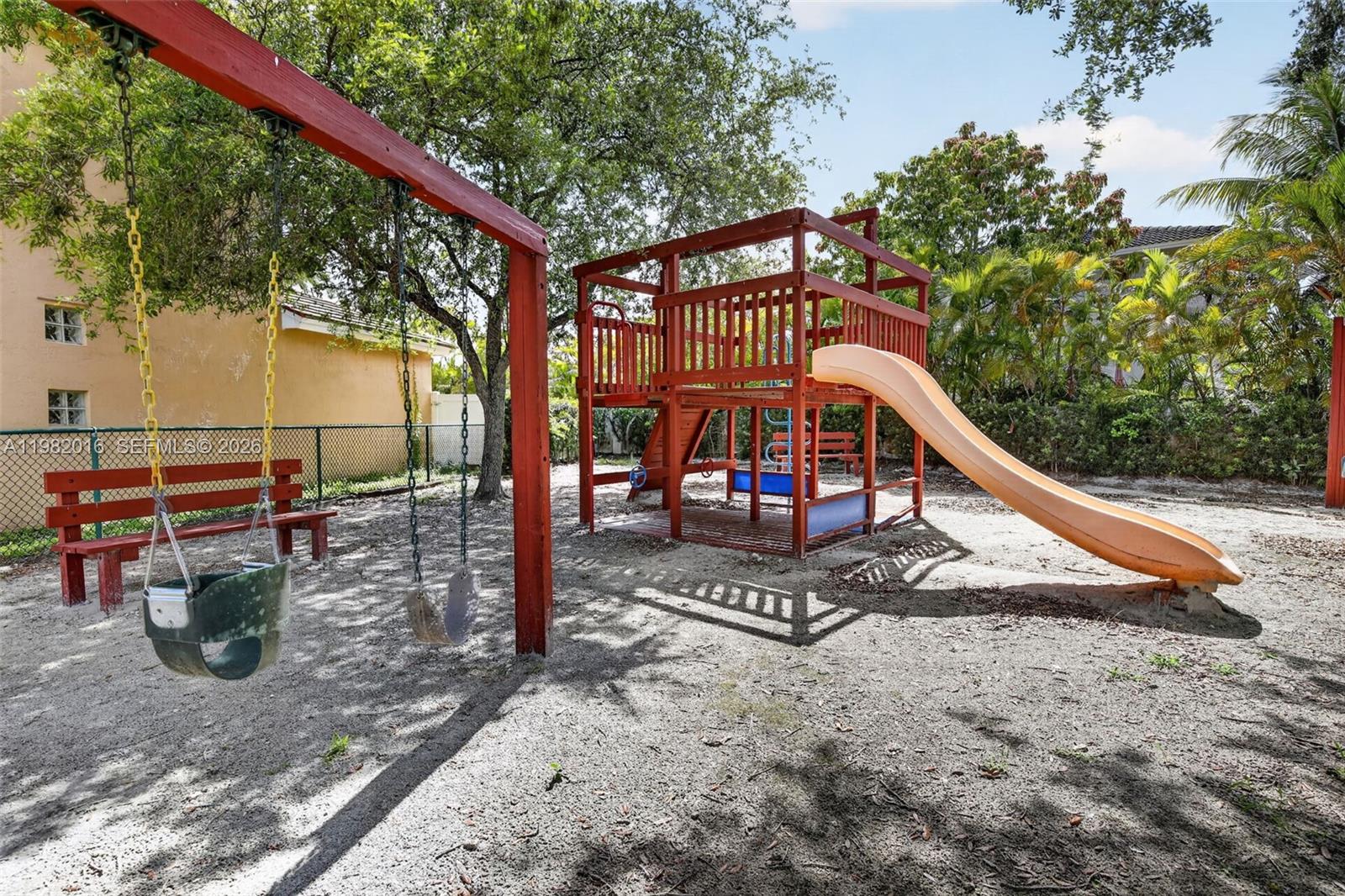 A playground with a wooden swing set, a climbing structure, and a slide on sand — 6955 SW 148th Ln, Davie FL 33331, DAVIE, FL