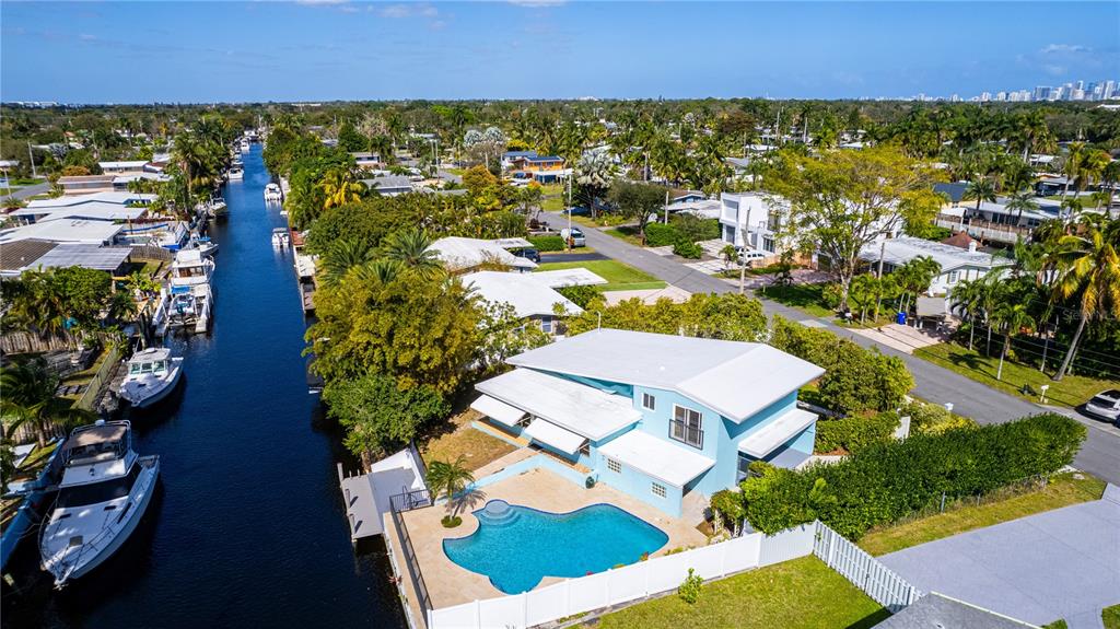 An aerial view shows a light blue house with a pool beside a canal — 2631 KEY LARGO LANE, FORT LAUDERDALE, FL