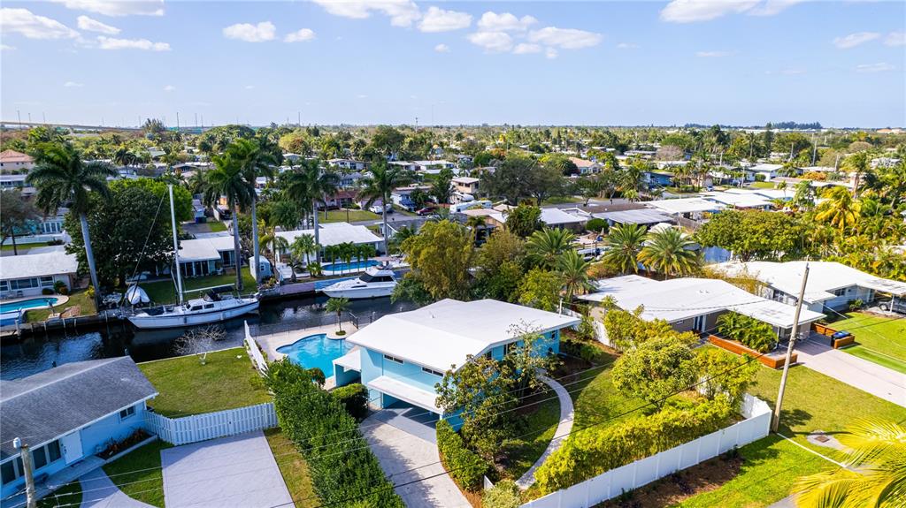An aerial view shows a blue house with a pool and boat dock on a canal — 2631 KEY LARGO LANE, FORT LAUDERDALE, FL