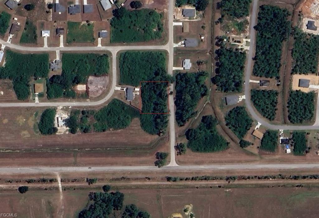 An aerial view shows a rectangular vacant lot outlined in red within a residential neighborhood — 3031 Mockingbird Lane, FL 33935, FL
