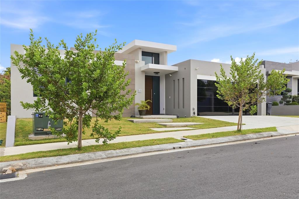 A modern, single-story house with a flat roof, gray exterior, and a two-car garage — Urb Las Casonas ARANDA, GUAYNABO, PR
