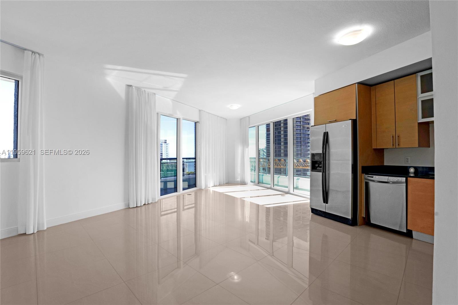 An open-concept living area features light tile flooring, floor-to-ceiling windows, and a modern kitchen — 60 SW 13th St # 1700, Miami FL 33130, MIAMI, FL
