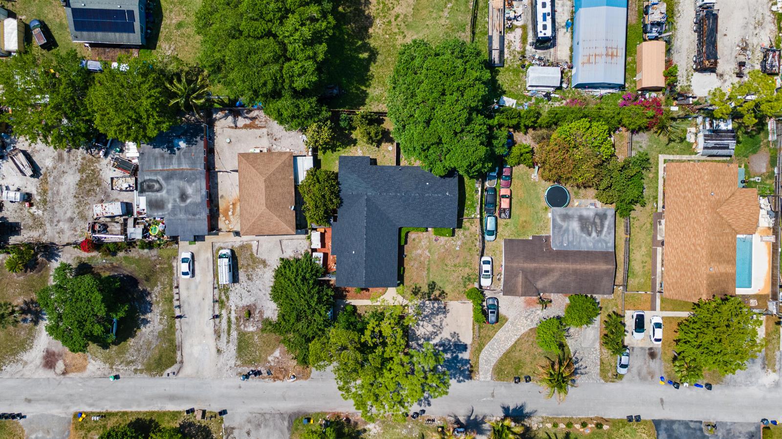 An aerial view shows several residential properties with houses, driveways, trees, and parked vehicles — 4453 Stevens Road, FL 33461, FL