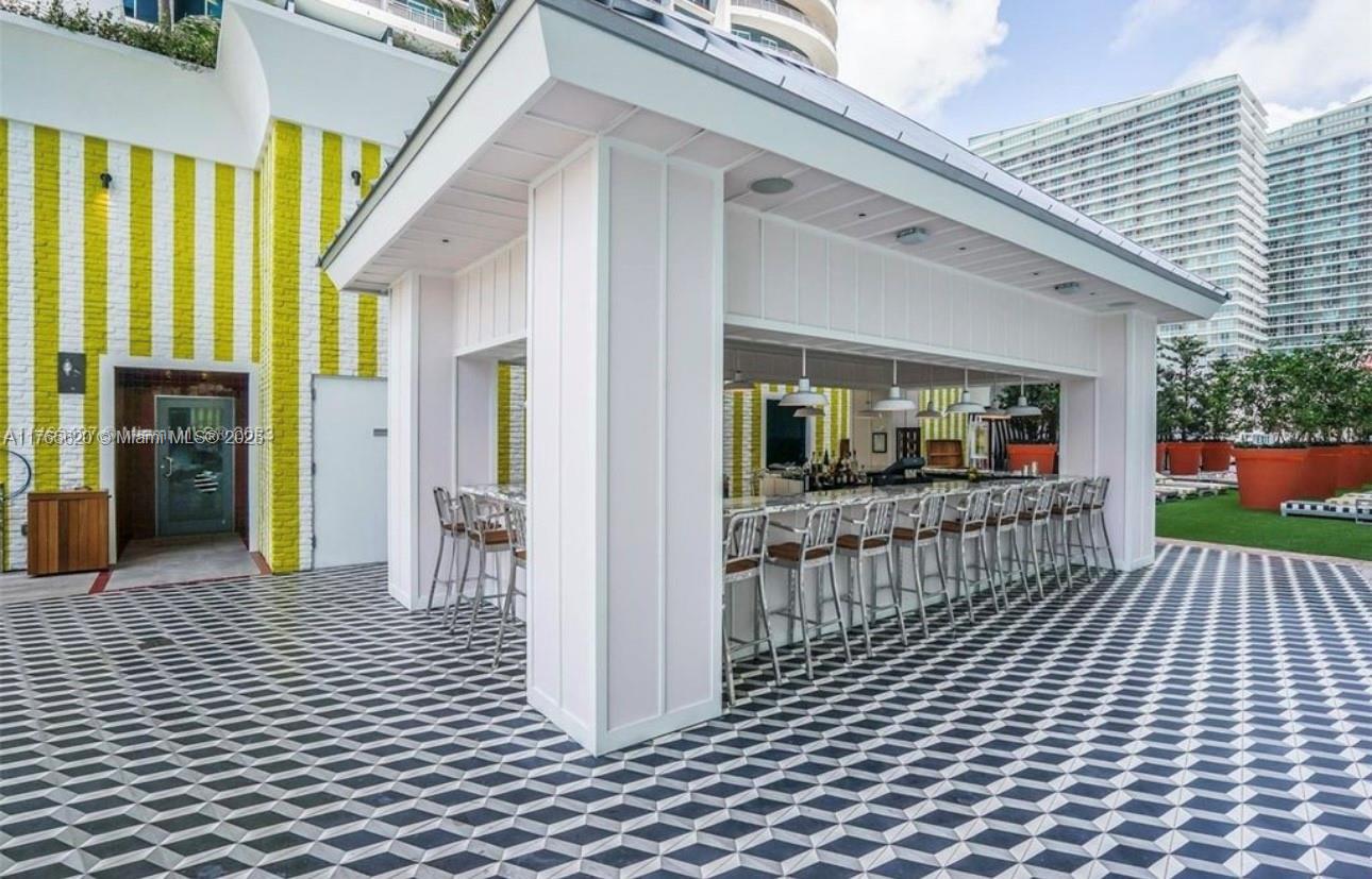 An outdoor bar area features a geometric tiled floor, white pillars, and a row of stools — 1300 S Miami Ave # 3108, Miami FL 33130, MIAMI, FL