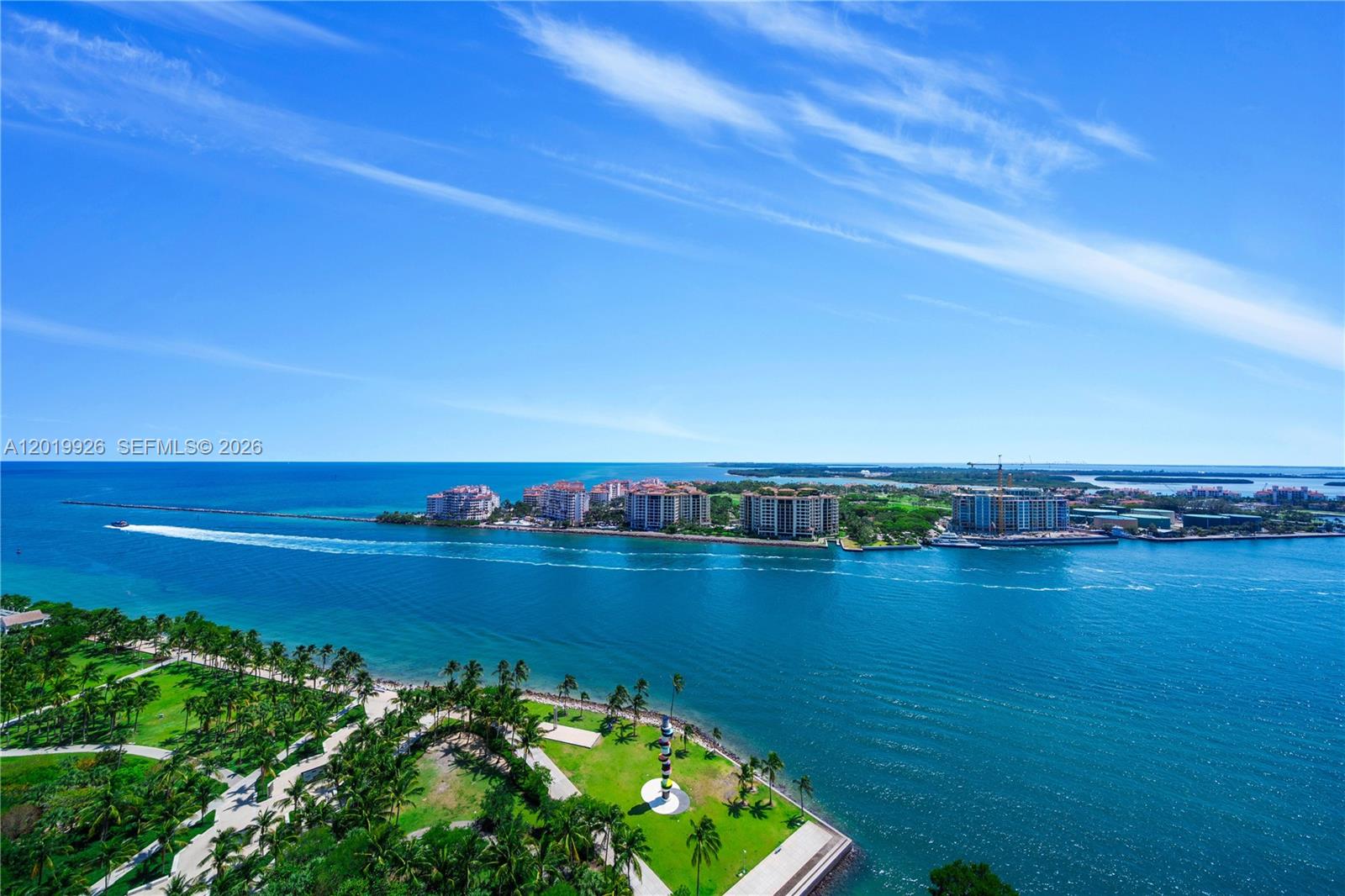 An aerial view shows a coastal park with palm trees overlooking a blue bay — 800 S Pointe Dr # 2204, Miami Beach FL 33139, MIAMI BEACH, FL