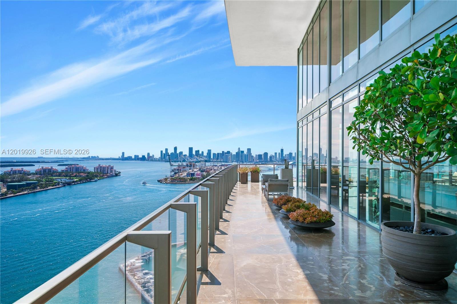 A spacious balcony features marble flooring, glass railings, and a panoramic view of the city — 800 S Pointe Dr # 2204, Miami Beach FL 33139, MIAMI BEACH, FL