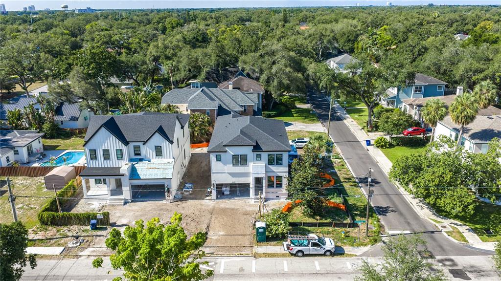 An aerial view shows two newly constructed white houses with dark roofs and unfinished landscaping — 4020 W CLEVELAND, TAMPA, FL