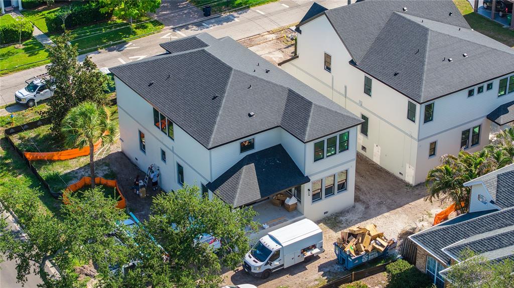 An aerial view shows two modern two-story houses under construction with a dumpster and van — 4020 W CLEVELAND, TAMPA, FL